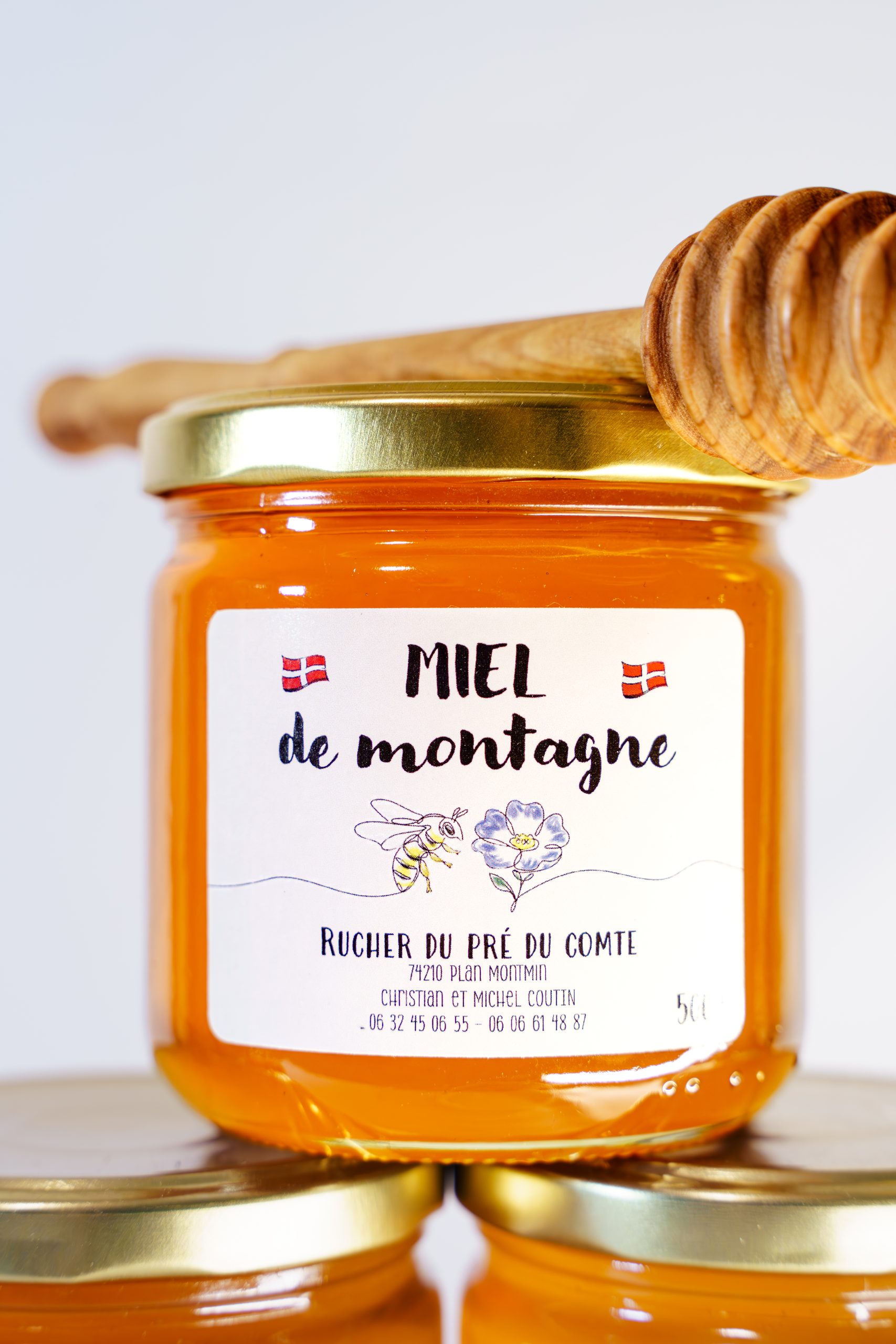 Packshot Produits Cuillere Bois Pot Miel De Montagne Rucher Du Pre Du Comte Scaled